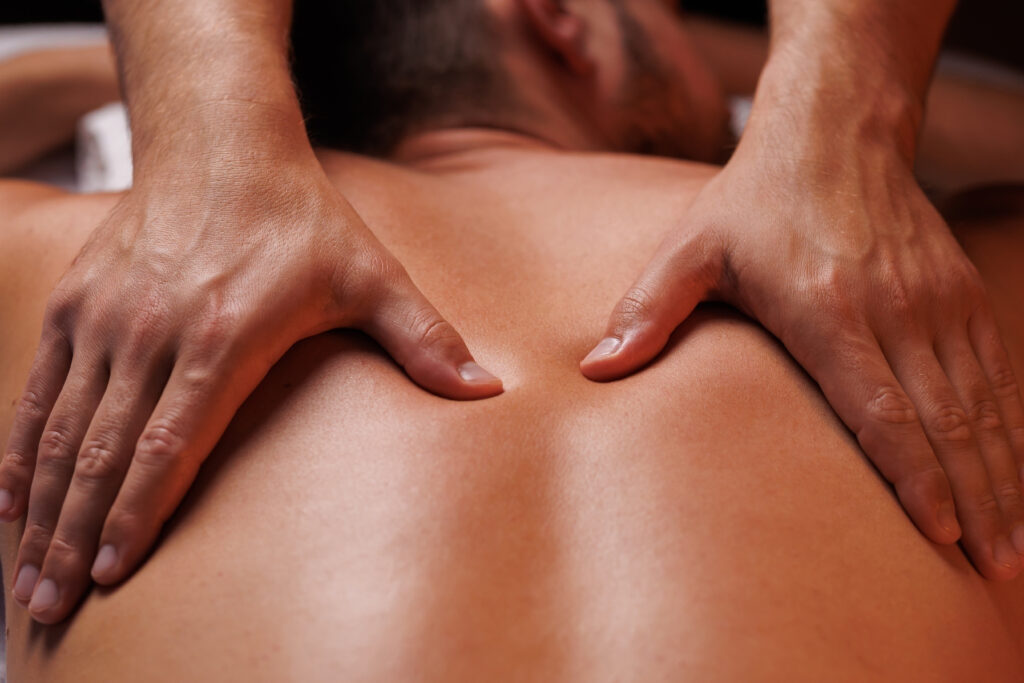 a person receiving massage gently pressing hands along clients back. Concept of aesthetic relaxing massage, remedial massage.